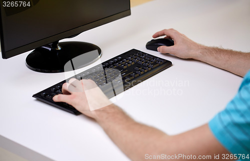 Image of close up of male hands with computer and keyboard