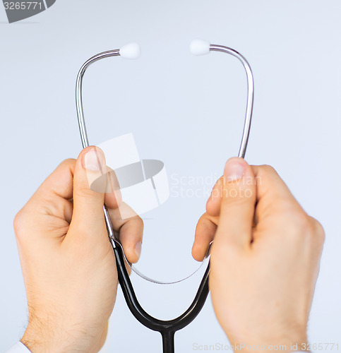 Image of doctor hand with stethoscope listening something