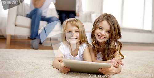 Image of happy little girls with tablet pc computer at home