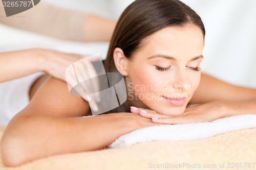 Image of beautiful woman in spa salon getting massage