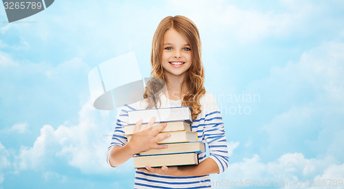 Image of happy little student girl with many books