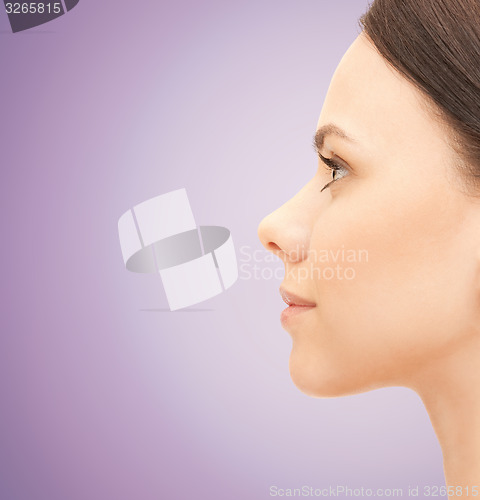 Image of beautiful young woman face over violet background