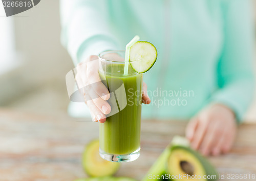 Image of close up of woman hands with juice and vegetables