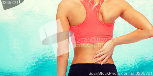 Image of close up of sporty woman touching her back