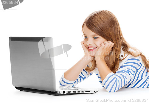 Image of smiling student girl with laptop computer lying