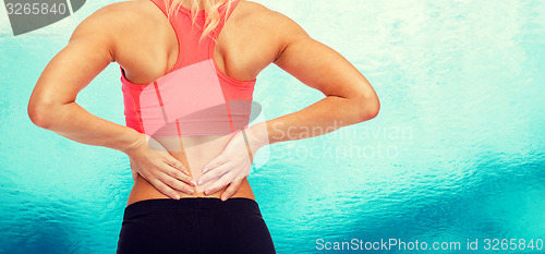 Image of close up of sporty woman touching her back