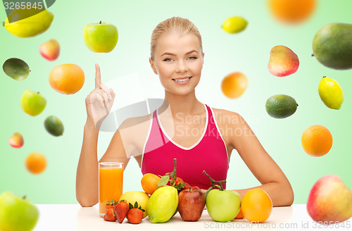 Image of woman with juice and fruits pointing finger up