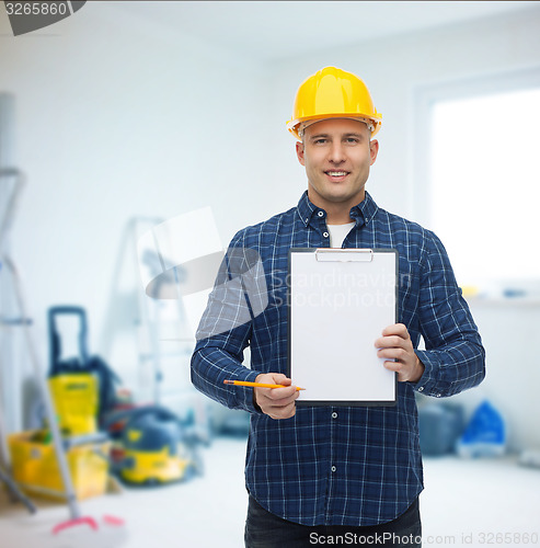 Image of smiling male builder in helmet with clipboard