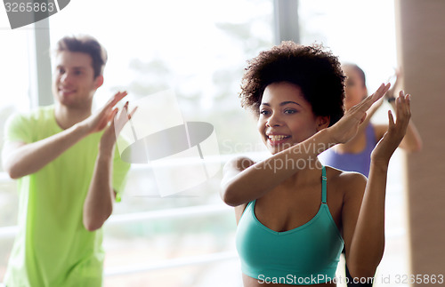 Image of group of smiling people dancing in gym or studio