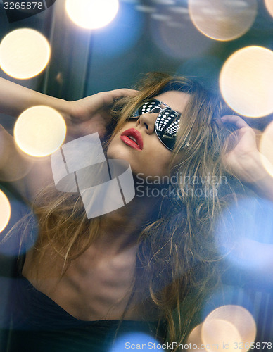 Image of beautiful woman in sunglasses in elevator