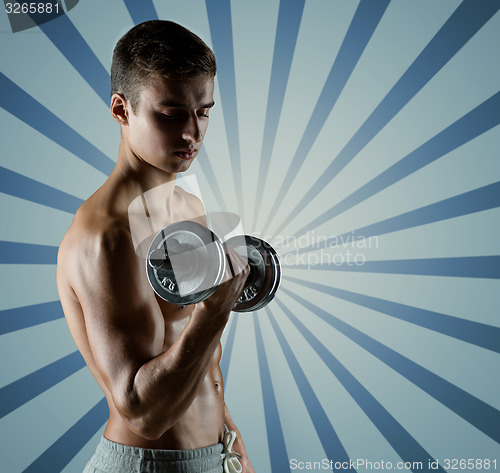 Image of young man with dumbbell flexing biceps