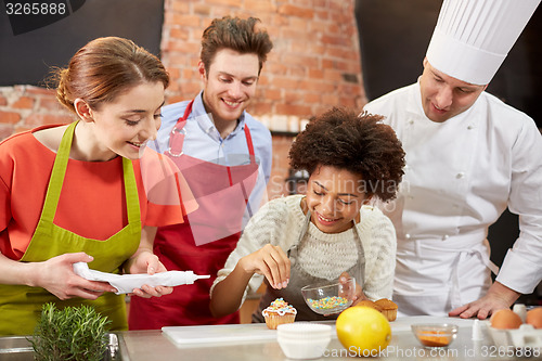 Image of happy friends and chef cook baking in kitchen