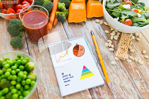 Image of close up of ripe vegetables and notebook on table