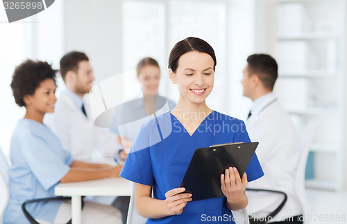 Image of happy doctor over group of medics at hospital