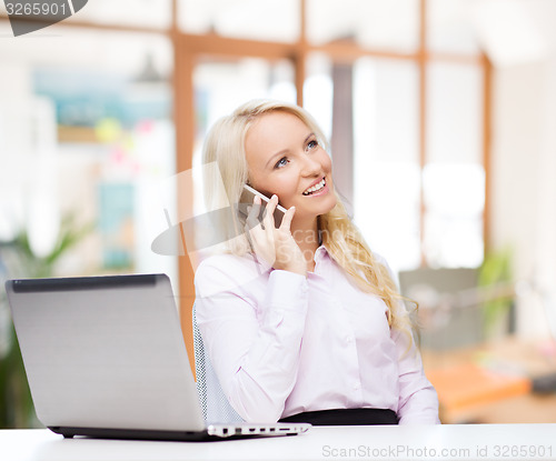 Image of smiling businesswoman calling on smartphone