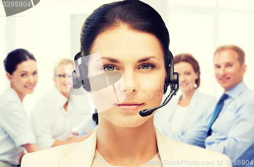 Image of helpline operator with headphones in call centre