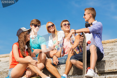 Image of group of smiling friends sitting on city street