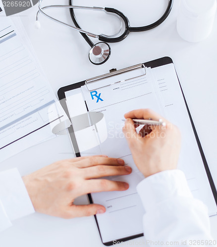 Image of male doctor writing prescription paper