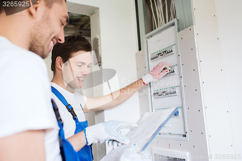 Image of builders with clipboard and electrical panel