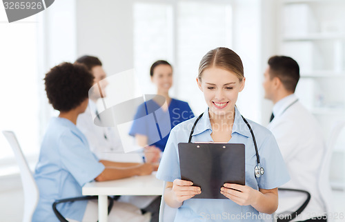 Image of happy doctor over group of medics at hospital