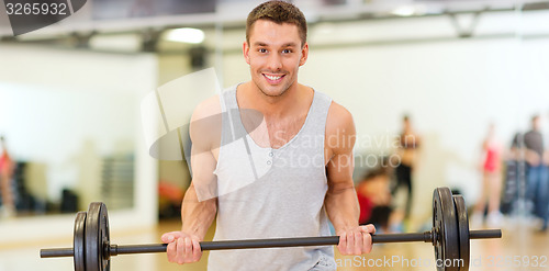 Image of smiling man with barbell in gym