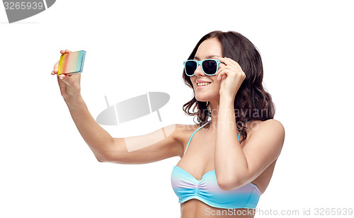 Image of woman in swimsuit taking selfie with smatphone