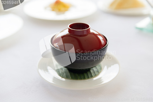 Image of ceramic pot with hot dish on restaurant table