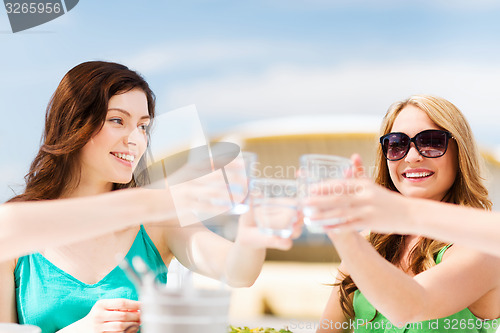 Image of girls making a toast in cafe on the beach