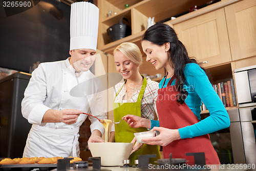 Image of happy women and chef cook baking in kitchen