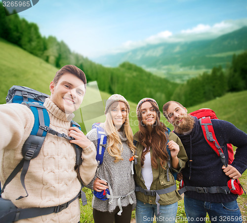 Image of group of smiling friends with backpacks hiking