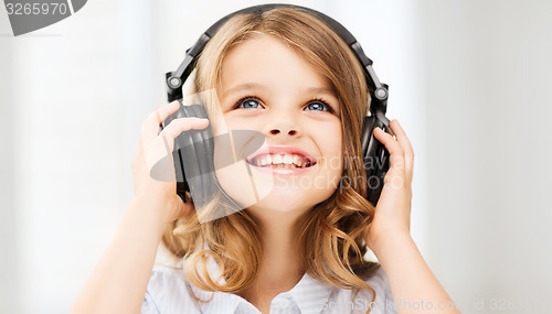 Image of little girl with headphones at home