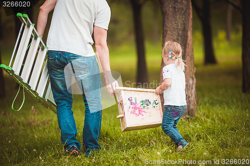 Image of Father making birdhouse with daughter