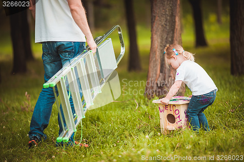 Image of Father making birdhouse with daughter