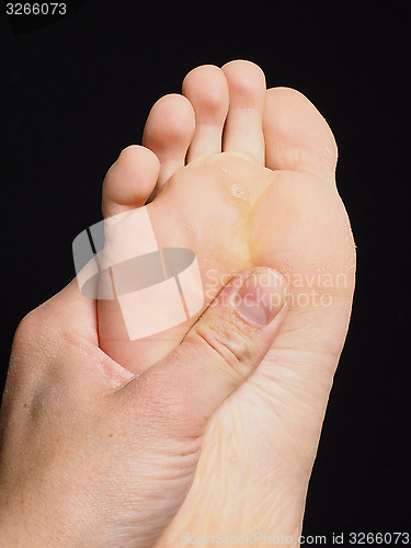 Image of Pressure point massage under foot with thumb isolated towards bl