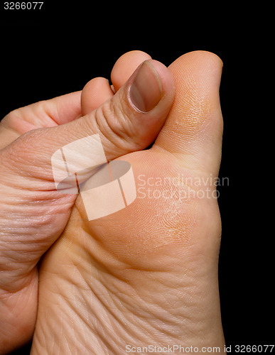 Image of Thumb pressure on big toe massage on dry skin isolated towards b