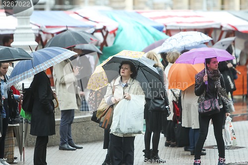 Image of People with umbrellas on square