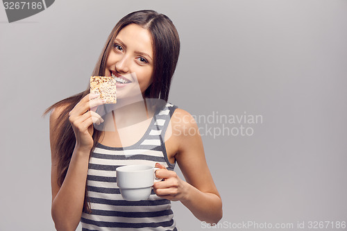 Image of Woman drinking hot drink from disposable paper cup