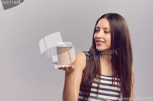 Image of Woman drinking hot drink from disposable paper cup