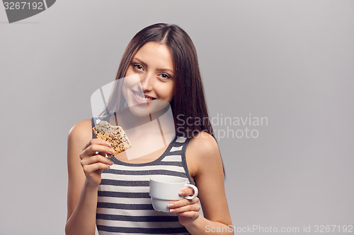 Image of Woman drinking hot drink from disposable paper cup