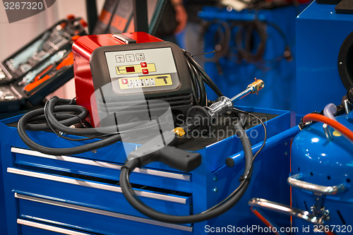Image of Modern welding gun on blue box