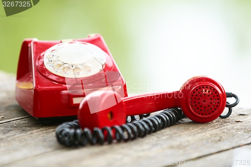 Image of Red phone on wooden deck