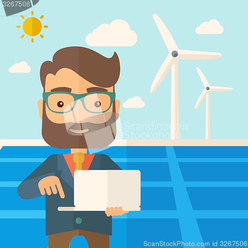 Image of Man with laptop in solar panel.