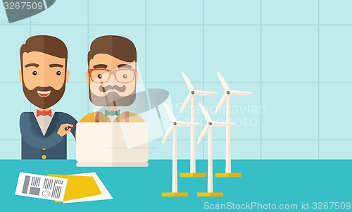 Image of Workers using laptop with windmills.