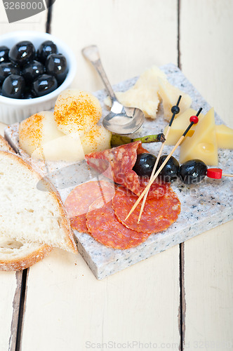 Image of mix cold cut on a stone with fresh pears