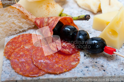 Image of mix cold cut on a stone with fresh pears