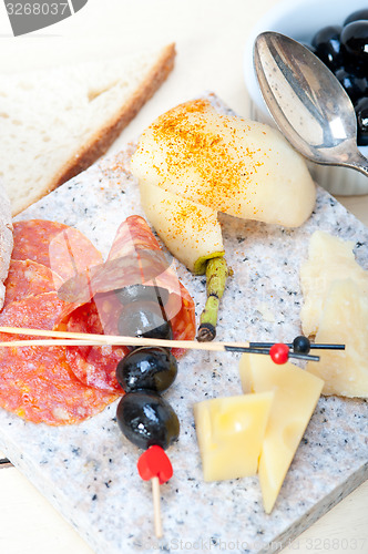 Image of mix cold cut on a stone with fresh pears