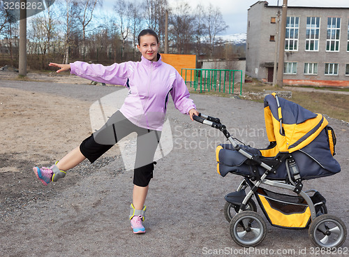 Image of young mother is engaged in fitness in a stadium