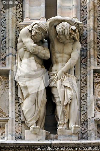 Image of statues in  front of the dome of milan