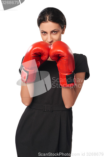 Image of Serious business woman wearing boxing gloves