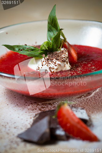 Image of strawberry soup with ice cream and mint on a plate decoratedfresh strawberries